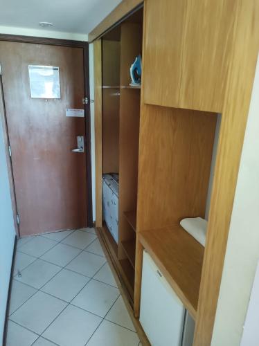 Habitación pequeña con armario y puerta en Flat Suite Natal, en Natal