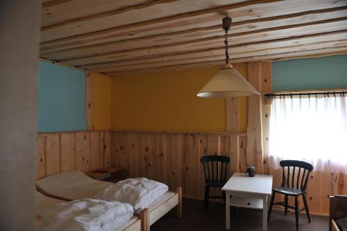 a bedroom with a bed and a table and chairs at Agroturystyka Kociewiak in Szteklin