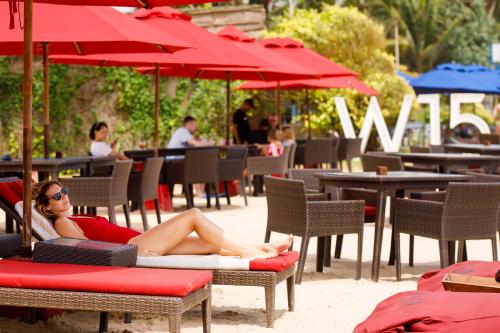 a woman laying on a beach chair under an umbrella at W15 Weligama in Weligama