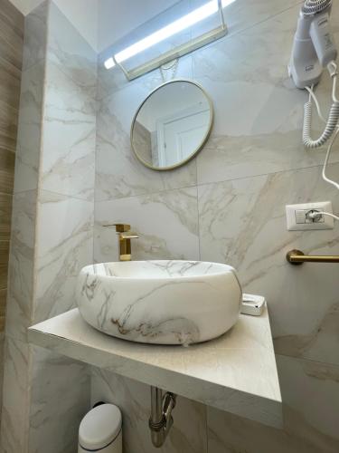 uma casa de banho com um lavatório branco e um espelho. em San Pietro Rooms 84 em Roma
