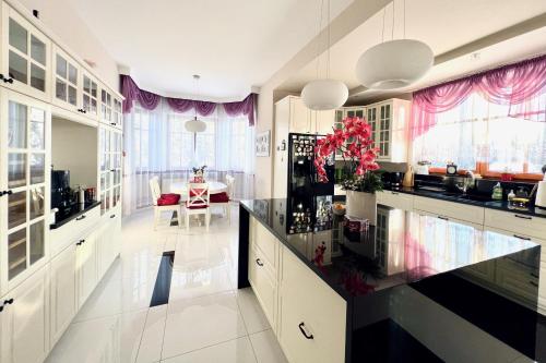 uma cozinha com armários brancos e cortinas roxas em Luxury Villa - JessApart Walendia em Walendów