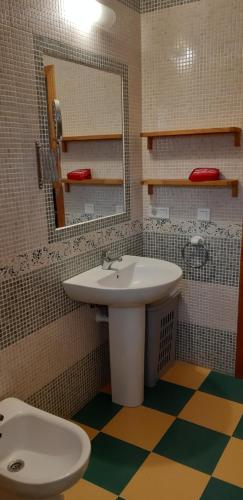 uma casa de banho com um lavatório, um espelho e um WC. em Cortijo Los Conquistadores em Lucena del Puerto
