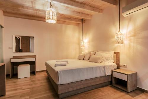 une chambre avec un lit, un bureau et des lustres dans l'établissement Myrovolos luxury Eneida's house, à Ialyssos