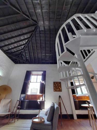 a living room with a spiral staircase and a couch at CASA YOOJ designers house in teguise in Teguise