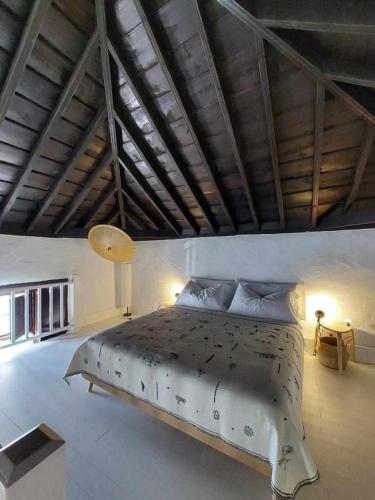 a bedroom with a large bed with a wooden ceiling at CASA YOOJ designers house in teguise in Teguise