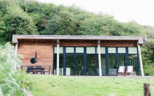 a cabin with glass doors and a table and chairs at Yorkshire Dales Lodge 6 by Together Travel - 3-Bed Family Retreat in Richmond