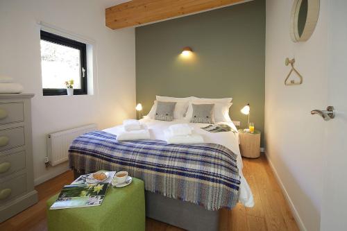a bedroom with a bed with a blue and white blanket at Yorkshire Dales Lodge 6 Family 3 bed in Richmond