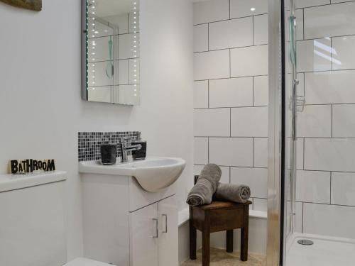 a white bathroom with a sink and a mirror at Y Gweithdy in Barmouth