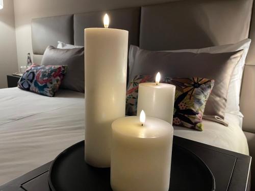 two white candles on a table in front of a bed at Residenza Palazzo Fortuna - Boutique Hotel in Civita Castellana