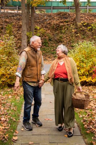 an older man and woman walking down a sidewalk at Hollinger House in Lancaster
