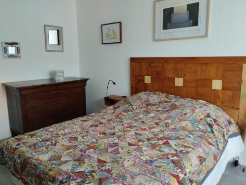 a bedroom with a bed with a quilt on it at La pause sous le pin B&B Chambres d'hôtes in Capestang