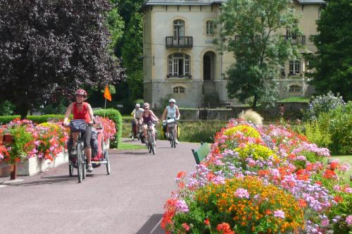 eine Gruppe von Personen, die vor einem Gebäude Fahrrad fahren in der Unterkunft Villa Tranquillité in Rohan