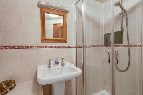 a bathroom with a sink and a shower at The Mountain Cottages - Millrace in Coniston