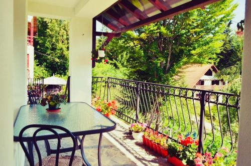 a patio with a table and chairs on a balcony at Iepurasul Sinaia in Sinaia