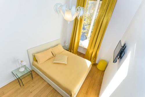 Cama pequeña en habitación con ventana en Boutique Apartment Elegantissima, en Turín