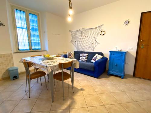 sala de estar con mesa y sofá azul en Appartamento Bucaniere en San Vincenzo