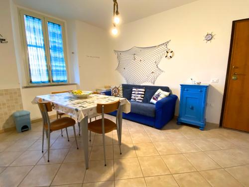 a living room with a table and a blue couch at Appartamento Bucaniere in San Vincenzo