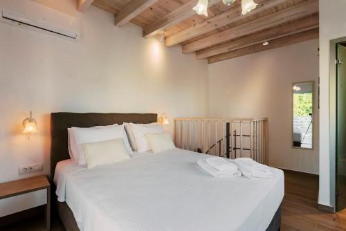 ein Schlafzimmer mit einem großen weißen Bett mit zwei Handtüchern darauf in der Unterkunft Myrovolos luxury Angie's house in Ialyssos