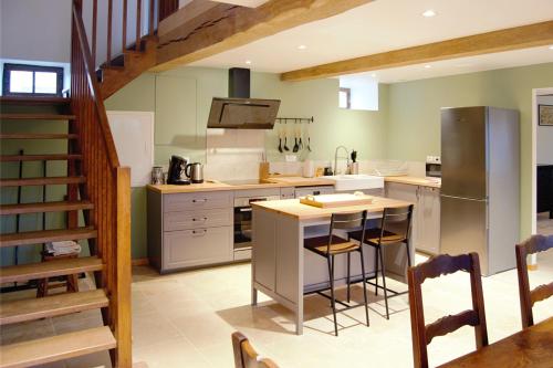 - une cuisine avec îlot central et comptoir dans l'établissement Le TilleRoy, à Painblanc