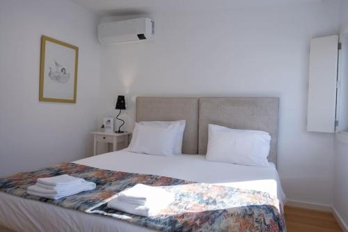 a bedroom with a large bed with white sheets and pillows at Porto Santa Maria Apartments in Porto