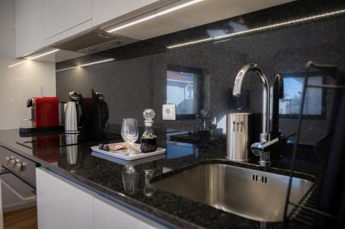 a kitchen with a sink and a wine glass at Porto Santa Maria Apartments in Porto