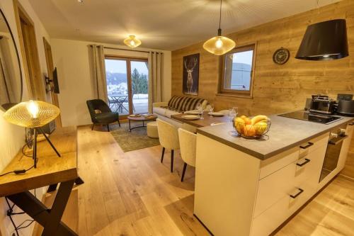 uma cozinha e sala de estar com mesa e cadeiras em Magnifique appartement dans luxueux chalet - ARAVIS em Crest-Voland