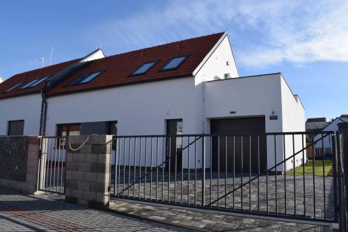 a white house with a black fence at Apartmány Pod Novou in Mikulov