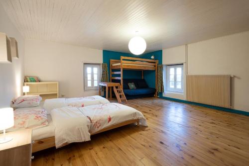 een slaapkamer met een bed en een stapelbed bij La Ferme du Bonheur - Un cocon d'authenticité au cœur de la nature in Cruseilles