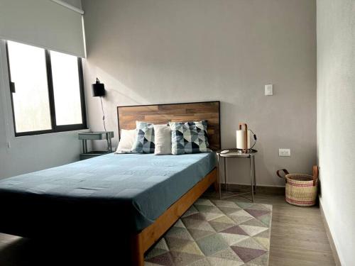 Casa con alberca en Residencial Portovela في نويفو فايارتا: غرفة نوم بسرير كبير عليها شراشف ووسائد زرقاء
