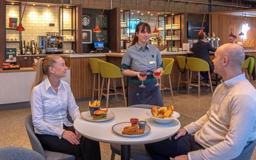 a group of people sitting around a table with food at Holiday Inn Sunderland - City Centre by IHG in Sunderland