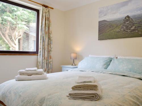 a bedroom with a bed with towels on it at Three Views Bungalow in Talgarth