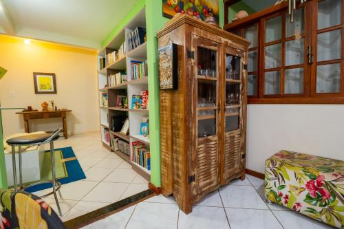 a room with a book shelf with books at A Casa Morro do Moreno in Vila Velha