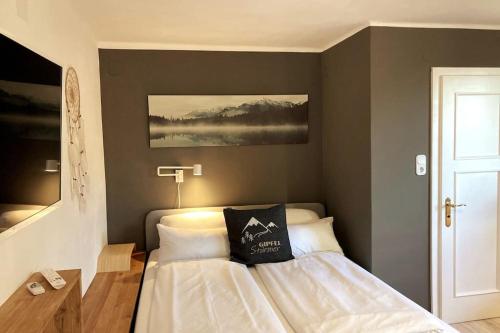 una camera da letto con un letto con un cuscino sopra di Wohnung mit Balkon in Velden - Appartment BERGE byTILLY a Velden am Wörthersee