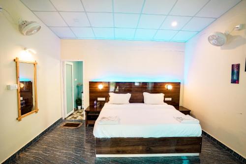 a bedroom with a bed and a mirror at orange sky beach bungalow in Agonda