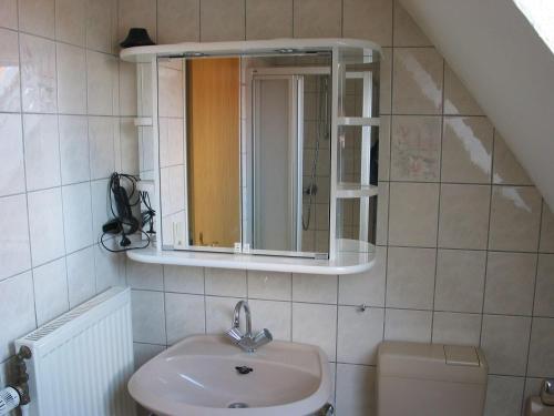 bagno con lavandino e specchio di Ferienhaus-Gretel a Greetsiel