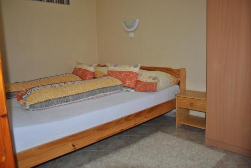 a wooden bed with pillows on it in a room at NAPSUGAR VENDÉGHÁZ in Bogács