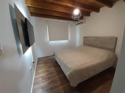 um quarto com uma cama e uma televisão de ecrã plano em Duplex equipado para 4 personas. em Godoy Cruz