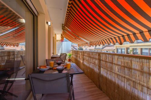 un patio avec une table et des chaises sur un balcon dans l'établissement #4 Papon Parking climatisé terrasse & wifi 5mins à pieds du Vieux Nice, à Nice