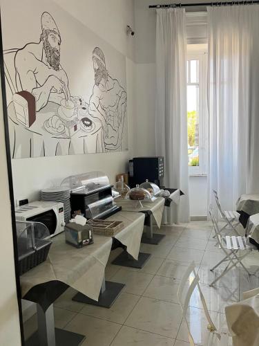 a living room with tables and a painting on the wall at Hotel Lungomare in Reggio Calabria