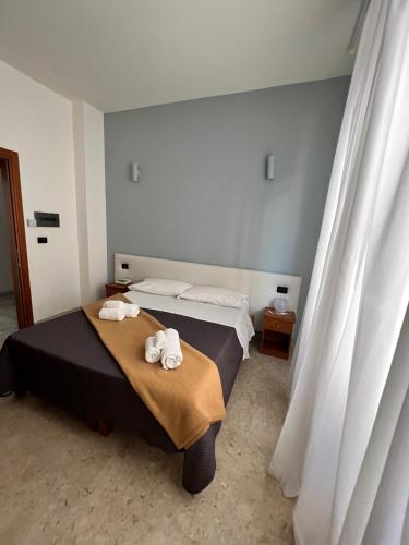 a bedroom with a bed with towels on it at Hotel Lungomare in Reggio Calabria