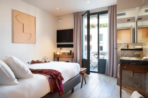 a hotel room with a bed and a balcony at Hébé Hotel in Annecy
