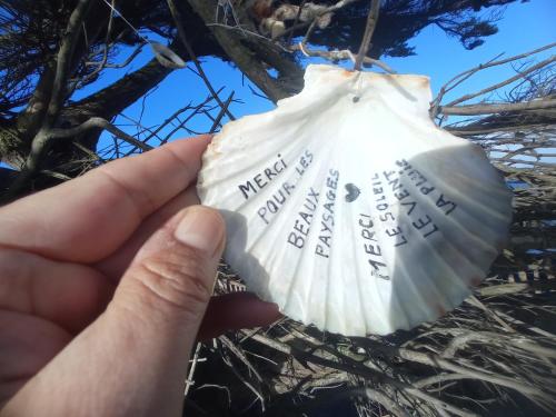 a hand holding a shell with words on it at Appartement dans gîte vue mer et campagne in Sibiril