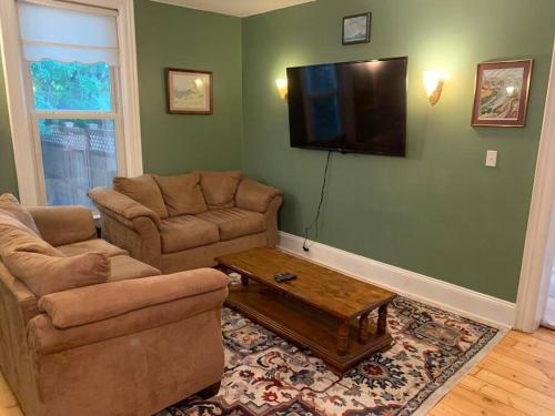 uma sala de estar com um sofá e uma televisão na parede em Trip6 Historic Brick Home em Helena