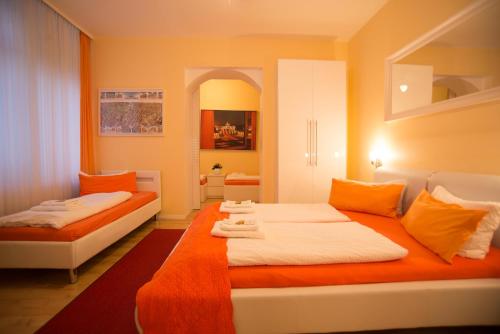 sypialnia z 2 łóżkami w kolorze pomarańczowym i białym w obiekcie City Guesthouse Pension Berlin w Berlinie