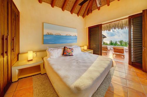 a bedroom with a bed and a view of the ocean at Residences at Las Palmas in Zihuatanejo