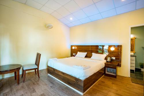 a bedroom with a bed and a table and a chair at orange sky beach bungalow in Agonda