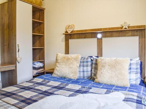 a bedroom with a bed with blue and white pillows at Nice Cottage In Ilfracombe With 3 Bedrooms And Wifi in Ilfracombe