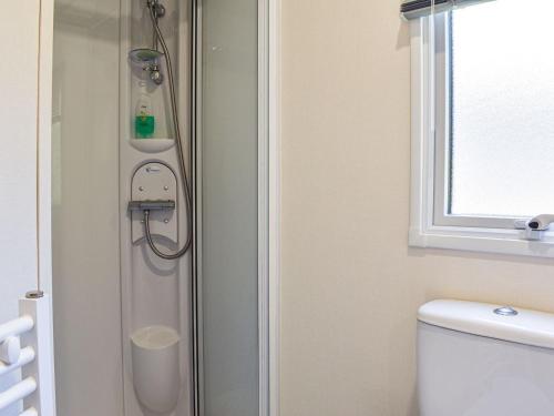 a bathroom with a shower with a toilet and a window at Nice Cottage In Ilfracombe With 3 Bedrooms And Wifi in Ilfracombe