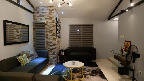 a living room with a couch and a table at Lax Uno 2 bedroom home with Parking, Wi-Fi, NetFlix and Airconditioned Rooms and Shower Heater in Antipolo