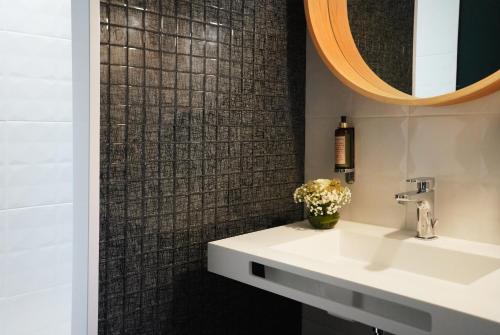 W łazience znajduje się umywalka i lustro. w obiekcie LOGIS Hôtel & Restaurant - LENSOTEL w mieście Lens